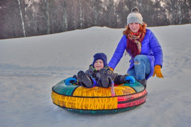 Mother and her son enjoying sleigh ride  clipart