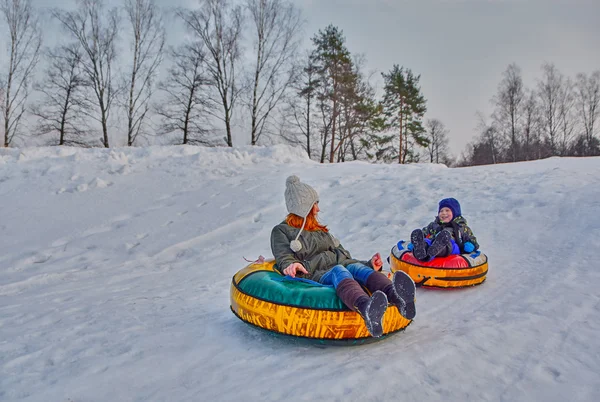 Gelukkige kinderen op een winter-slee rijden — Stockfoto
