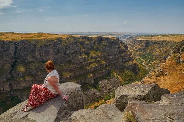 Young woman sitting on the edge of Kasagh river gorge — Stock Photo, Image