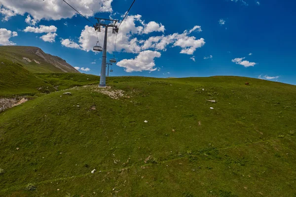 Luchtfoto kabelbaan hoog in de bergen van de Kaukasus met gras plai — Stockfoto