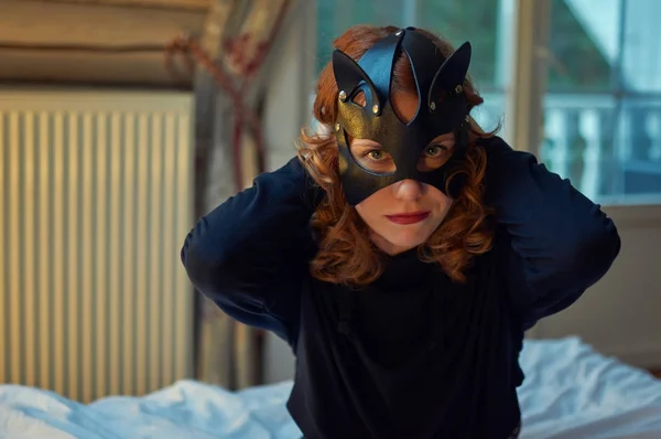 魅惑的な猫のマスクで若い赤毛の女性 — ストック写真