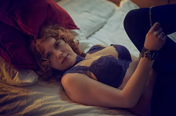 Femme rousse menottée dans un lit confortable — Photo