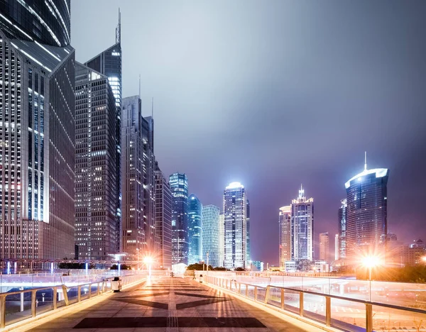 Pedestrian bridge and modern buildings at night — Stock Photo, Image