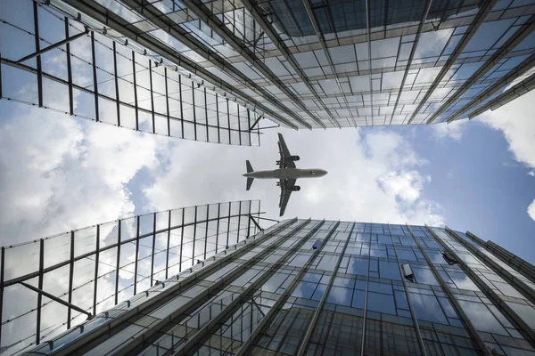 Airplane and modern buildings — Stock Photo, Image