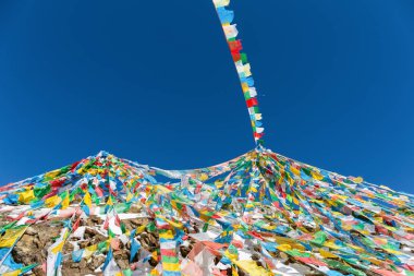 Rüzgar-at bayrakları Tibet'te mavi gökyüzü karşı