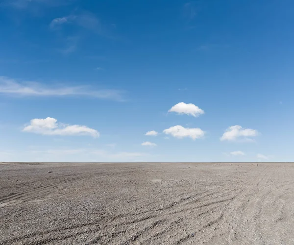 Blauwe hemel en grind grond — Stockfoto