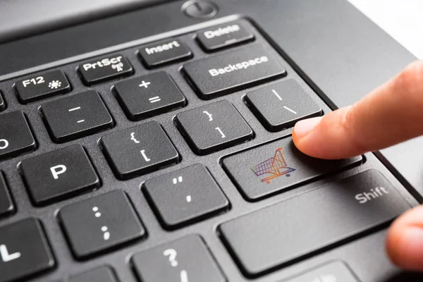 Laptop keyboard with finger pressing shopping cart key — Stock Photo, Image