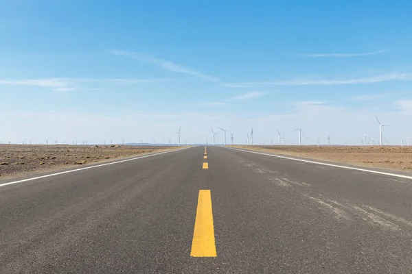 風力発電所や青空の広がる荒野の高速道路 — ストック写真