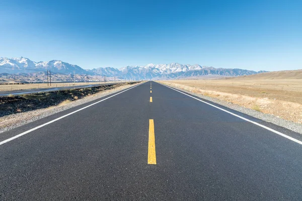 Uzak araziye giden boş asfalt yolu, otoyol arka planı