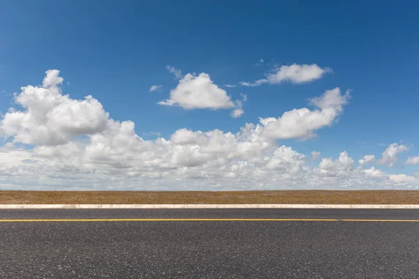 空の草原を背景に空の道 — ストック写真