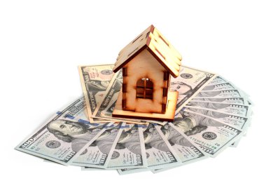 Tahta bir ev ve bir deste Amerikan kağıdı zenginliğin sembolü olarak dolarları gösteriyor.