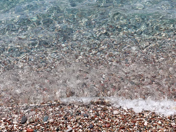 clear sea water covers the pebble Mediterranean beach