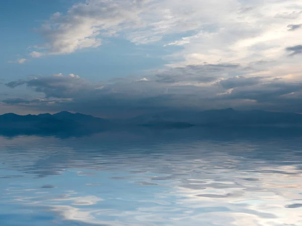 reflection of a cloudy sky in a calm surface of the sea