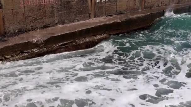 海岸の防波堤で波が砕けて岩の多い海岸に落ち — ストック動画