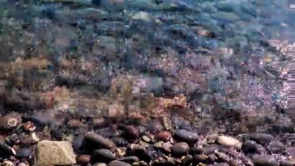 清澈的水覆盖着海滩上的石头 — 图库视频影像