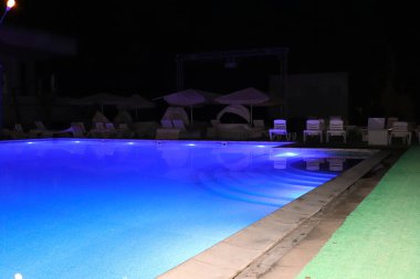 Rahatlamak için temiz su ve hamakları olan havuz.