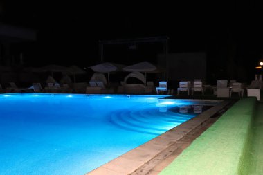 Rahatlamak için temiz su ve hamakları olan havuz.