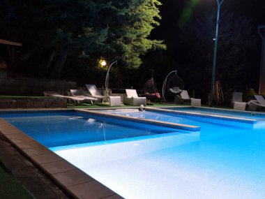 Rahatlamak için temiz su ve hamakları olan havuz.