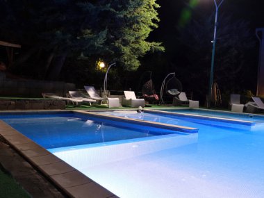 Rahatlamak için temiz su ve hamakları olan havuz.