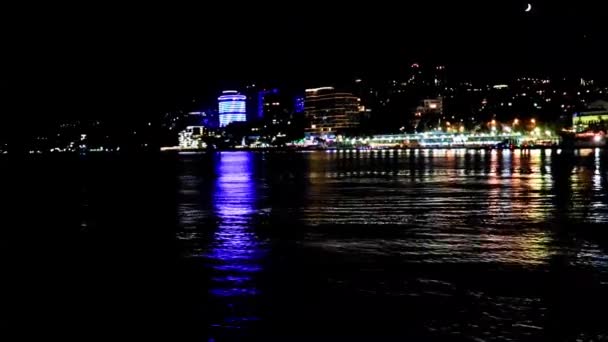 从海面俯瞰克里米亚共和国雅尔塔共和国建筑物和商业海港的夜景 — 图库视频影像