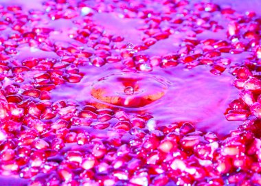 Olgun nar taneleri taze meyve suyunda yüzer.