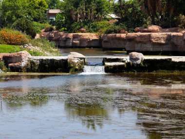 Antalya Türkiye 'nin Lara yerleşim alanındaki pitoresk botanik parkında küçük bir şelale.