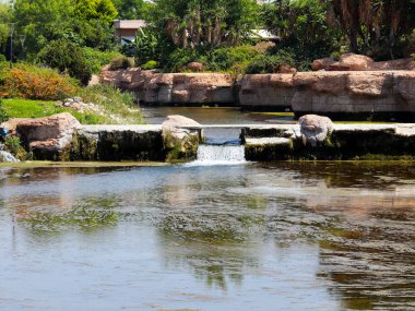 Antalya Türkiye 'nin Lara yerleşim alanındaki pitoresk botanik parkında küçük bir şelale.