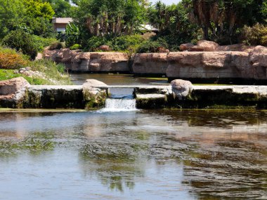 Antalya Türkiye 'nin Lara yerleşim alanındaki pitoresk botanik parkında küçük bir şelale.