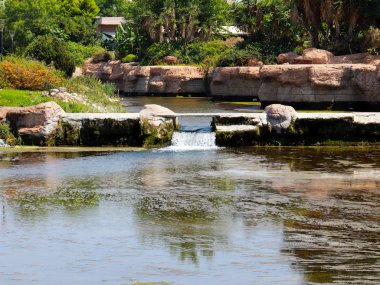 Antalya Türkiye 'nin Lara yerleşim alanındaki pitoresk botanik parkında küçük bir şelale.