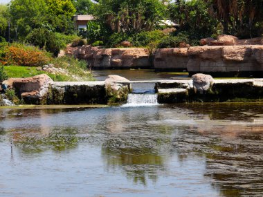 Antalya Türkiye 'nin Lara yerleşim alanındaki pitoresk botanik parkında küçük bir şelale.