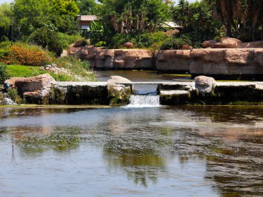 Antalya Türkiye 'nin Lara yerleşim alanındaki pitoresk botanik parkında küçük bir şelale.