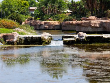 Antalya Türkiye 'nin Lara yerleşim alanındaki pitoresk botanik parkında küçük bir şelale.