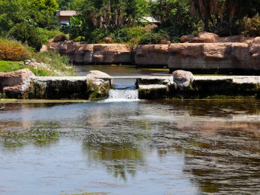Antalya Türkiye 'nin Lara yerleşim alanındaki pitoresk botanik parkında küçük bir şelale.