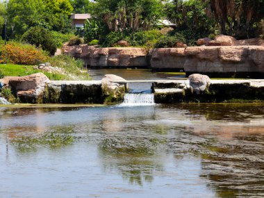 Antalya Türkiye 'nin Lara yerleşim alanındaki pitoresk botanik parkında küçük bir şelale.