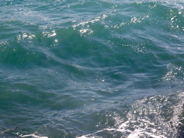 Köpük ve dalgalar denizin yüzeyinde