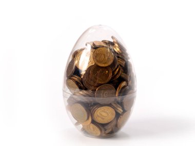 a large transparent Easter egg with a bunch of metal coins of Russian rubles