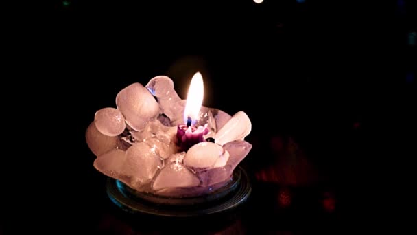 純粋な氷に囲まれたワックスキャンドルの炎の明るい光 — ストック動画