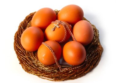 Paskalya bayramı, bahar ayininin sembolü olarak zincirli altın haç ve bayram yumurtası.