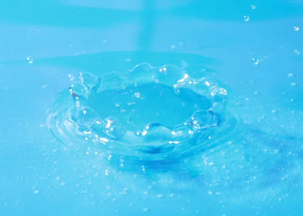 trace on the surface of a clean liquid after being hit by a drop of water