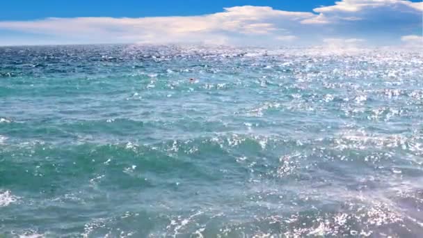 海浪和阳光灿烂的天空下的石滩 — 图库视频影像