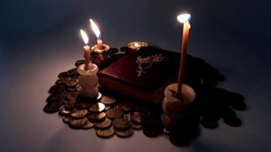 Parlak dini mumlar ve altın haçlı bir kitap.