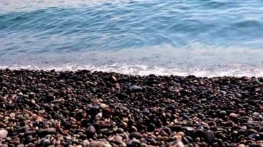 Sahilde kum ve çakıl taşı kumsalı ve deniz dalgaları