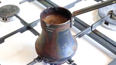Mutfaktaki gaz sobasının üzerinde eski bir metal kahve makinesinde koyu sade kahve yapmak.