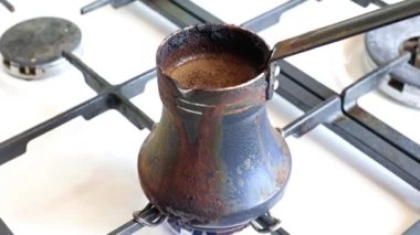 Mutfaktaki gaz sobasının üzerinde eski bir metal kahve makinesinde koyu sade kahve yapmak.