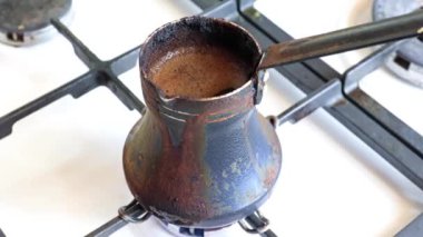 Mutfaktaki gaz sobasının üzerinde eski bir metal kahve makinesinde koyu sade kahve yapmak.