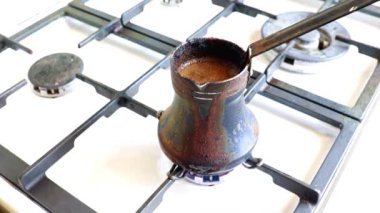 Mutfaktaki gaz sobasının üzerinde eski bir metal kahve makinesinde koyu sade kahve yapmak.