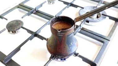 Mutfaktaki gaz sobasının üzerinde eski bir metal kahve makinesinde koyu sade kahve yapmak.