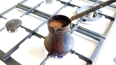 Mutfaktaki gaz sobasının üzerinde eski bir metal kahve makinesinde koyu sade kahve yapmak.