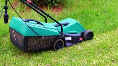Çimleri biçerken elektrikli bahçe çim biçme makinesi hareketi