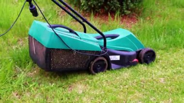 Çimleri biçerken elektrikli bahçe çim biçme makinesi hareketi